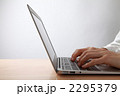 テーブルでノートパソコンを操作する