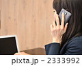 スマートフォンで話すビジネスウーマン(カフェ・後姿)
