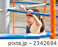 公園の遊具で元気に遊ぶ女の子