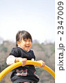 公園の遊具で元気に遊ぶ女の子
