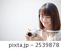 カメラをもって微笑む若い女性