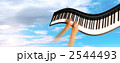 くねったピアノを弾く両手 青空