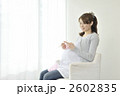 窓辺で編み物をする妊婦