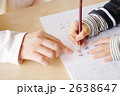 親が子供に勉強を教えるシーン