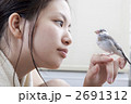 文鳥のヒナを手に乗せる女性