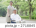 公園を散歩するシニアとヘルパー