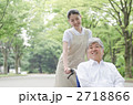 公園を散歩するシニアとヘルパー
