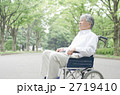 車イスで公園を散歩するシニア
