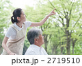 公園を散歩するシニアとヘルパー