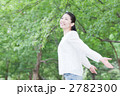 木々の中で深呼吸をする女性
