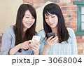 スマートフォンを見る女性ふたり_横