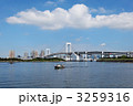 青空が広がるお台場海浜公園のレインボーブリッジと調査船