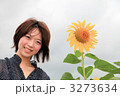 笑う若い女性の視線と向日葵／曇り空