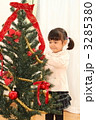 クリスマスツリーに飾り付けする女の子
