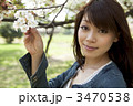 桜を手にとり見つめる女性 桜を手にとり見つめる女性