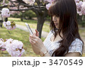 桜をスマートフォンで撮る女性 桜をスマートフォンで撮る女性