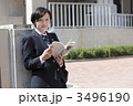 校門の前で教科書を開く女子高生
