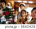 クリスマスツリーの周りで微笑む若者たち