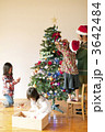 クリスマスツリーの飾り付けをする子供たちと母親
