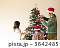 クリスマスツリーの飾り付けをする子供たちと母親