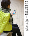 スマートフォンの音声再生を聴く女性