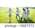 布を持ち草原を歩く若者たち