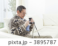 カメラのメンテナンスをするシニア男性