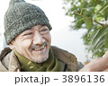 防寒着を着て植木を触るシニア男性