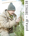防寒着を着て植木を触るシニア男性