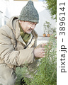 防寒着を着て植木を触るシニア男性