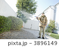 真冬に庭に水をまくシニア男性