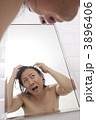 頭髪をチェックする男性