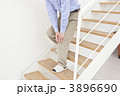 膝痛で辛そうに階段を下りるシニア男性