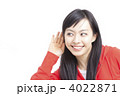 耳に手を当てる女性