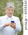 スマートフォンを持つシニア男性（屋外）
