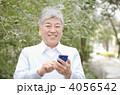 スマートフォンを持つシニア男性（屋外）