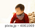 木のおもちゃに囲まれている1歳の赤ちゃん