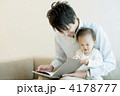 子どもに本を見せる父
