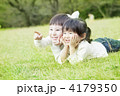 芝生で頬杖をつく子供達