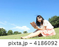 快晴の空の下、読書する女子大生