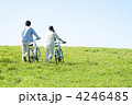草原で自転車を押すカップルの後姿