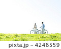 草原で自転車を押すカップル