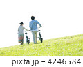 草原で自転車を押すカップルの後姿