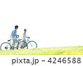 草原で自転車を押すカップル