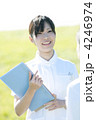 草原でファイルを持ち微笑む看護師