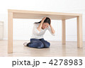 机の下に隠れる女性
