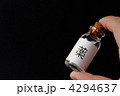 「薬」ラベルの小瓶を持つ手