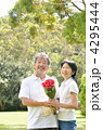 バラの花束を手に笑顔の50代夫婦