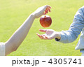 草原でリンゴを渡すカップルの手元