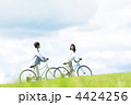 草原で自転車を押すカップル